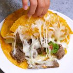 Mulita Taco is loaded with gooey melted cheese and a flavorful carne asada, with crispy tacos on both sides. Talk about mouth-watering Mexican comfort food everyone loves! It’s a double-deck quesadilla with two tortillas and meat on the inside.