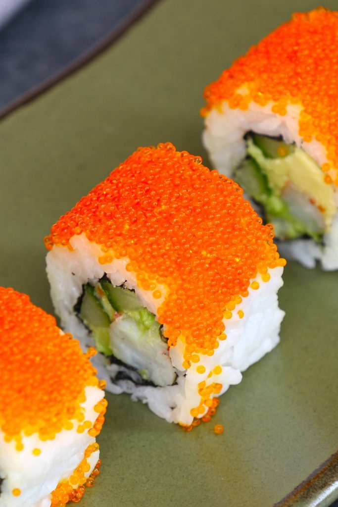 Roe sushi is made with tobiko roes and your favorite sushi rolls. Tobiko is the Japanese word for flying fish roe, which is crunchy and salty with a hint of smoke. It’s a popular ingredient in Japanese cuisine as a garnish to sushi rolls.